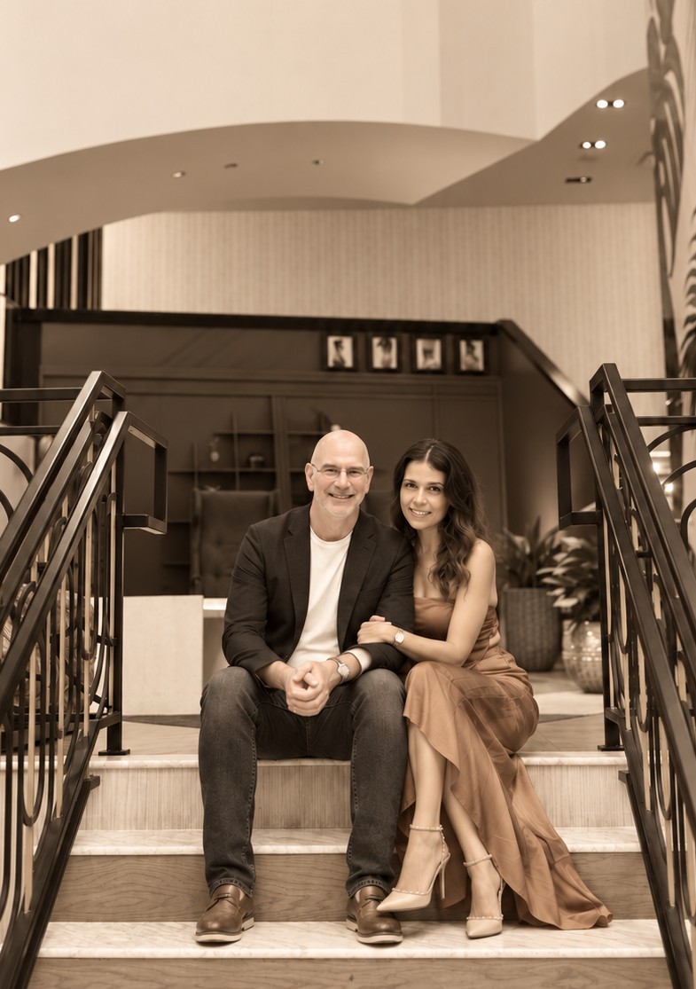 Timothy and Alejandra, the founders of Allie's, seated on a hotel staircase